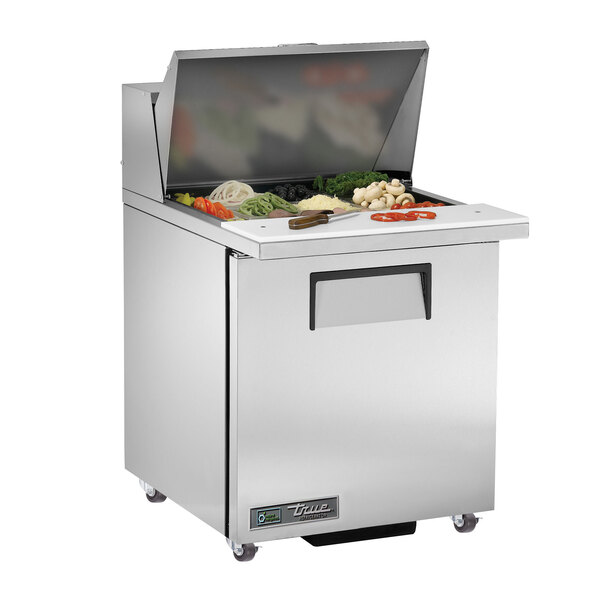 A True stainless steel refrigerated sandwich prep table with a large food tray on the counter.