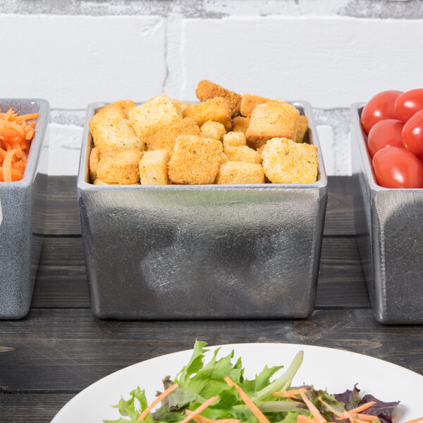 A table with Tablecraft metal bowls filled with food.