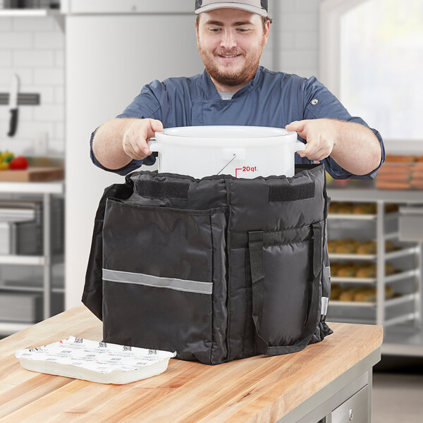 A man holding a white container with a grey stripe bag.