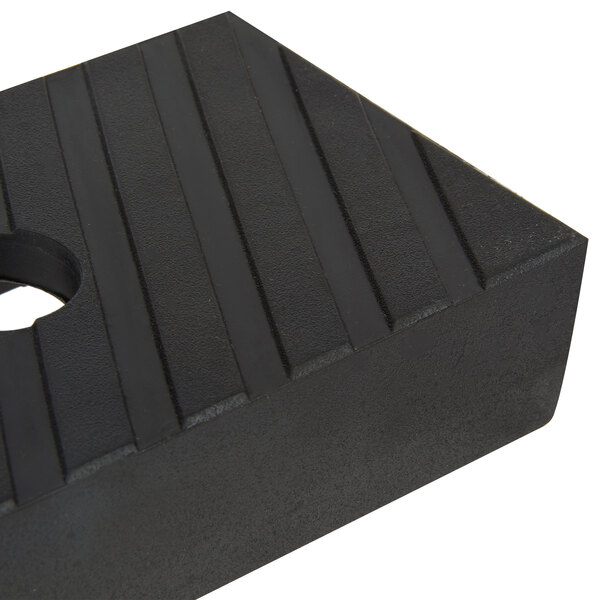 A close up of a black rectangular rubber foot with a hole in it.