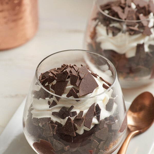 A glass dish of chocolate pudding topped with whipped cream and Dark Chocolate Flakes.