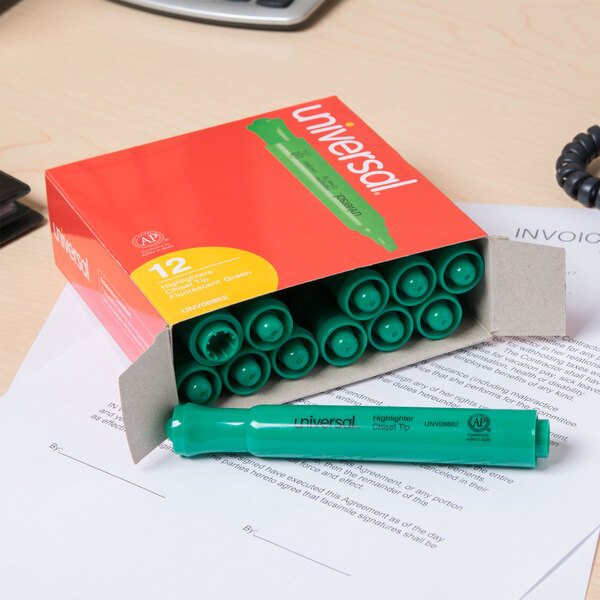 A box of Universal fluorescent green chisel tip highlighters on a desk.