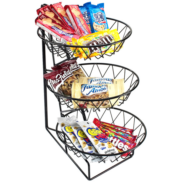 A three tiered wire basket with snacks and candy.