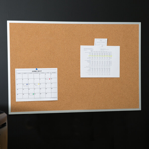 A Universal cork board with a calendar and a piece of paper on it.