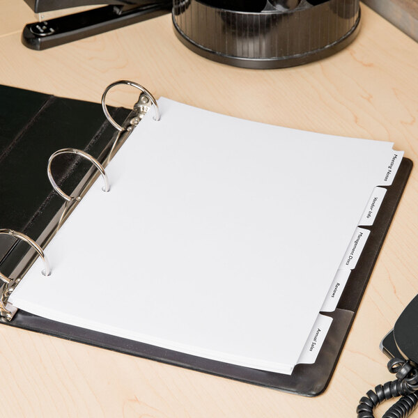 A binder with Avery white printable tabs on it.