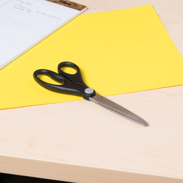 Universal UNV92008 7" Stainless Steel Economy Scissors cutting a yellow piece of paper.