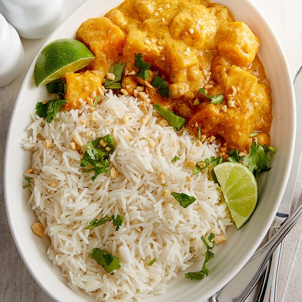 A white bowl filled with Royal Chef's Secret Sella Parboiled Basmati Rice with a lime wedge on the side.