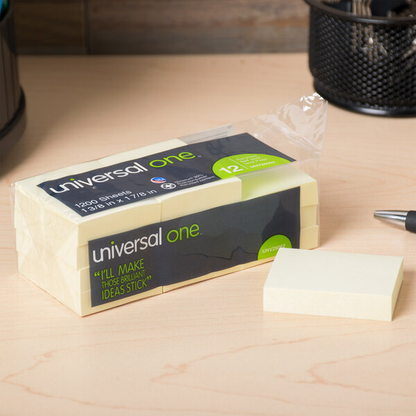 A pack of Universal yellow sticky notes on a desk.
