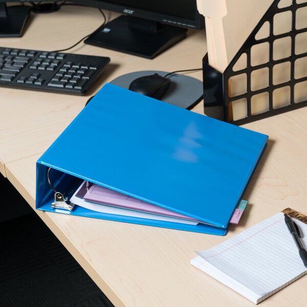 A light blue Universal deluxe non-stick view binder on a table.