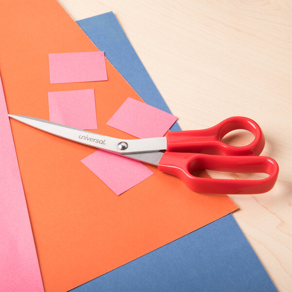 A Universal 3-pack of stainless steel scissors with red bent handles on a table.