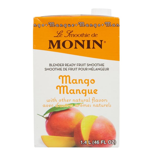A carton of Monin mango fruit smoothie mix on a table.