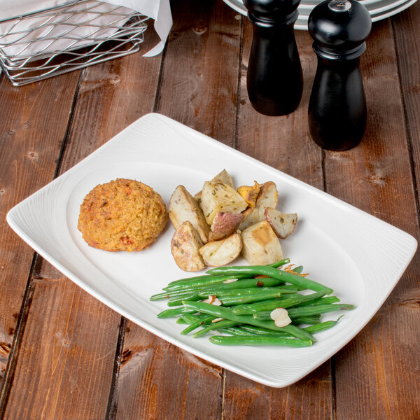 A Reserve by Libbey rectangular white porcelain platter with green beans, potatoes, and a green bean.