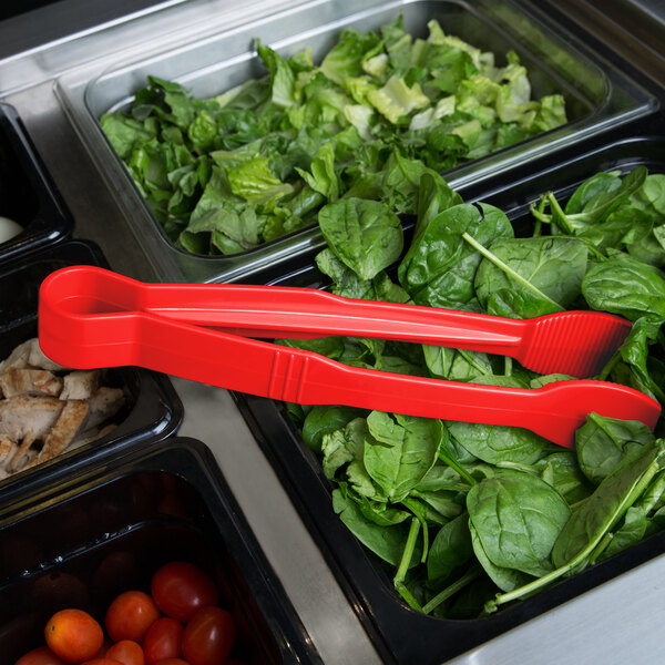 Red Thunder Group polycarbonate flat grip tongs in a container of lettuce at a salad bar.