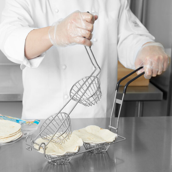 A chef using a Tablecraft fry basket to hold tortillas.