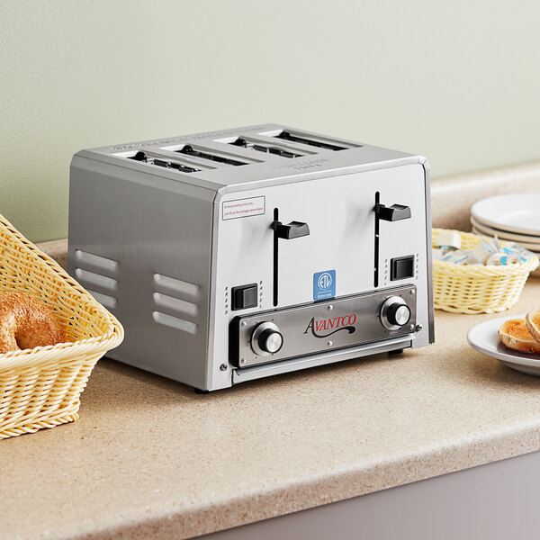 An Avantco commercial toaster on a counter with bread and bagels in the slots.