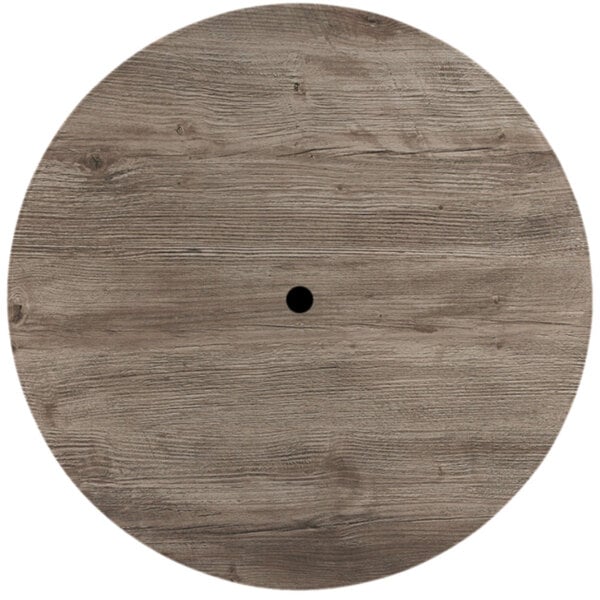 A Grosfillex round wood table top with a hole in the middle.