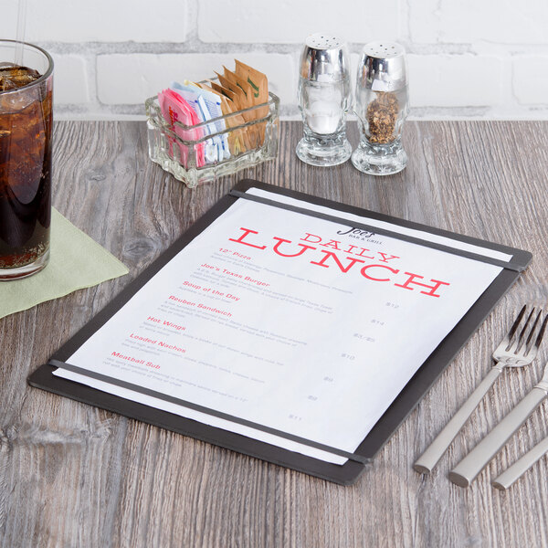 A black Cal-Mil menu board with a drink and a fork on a table.