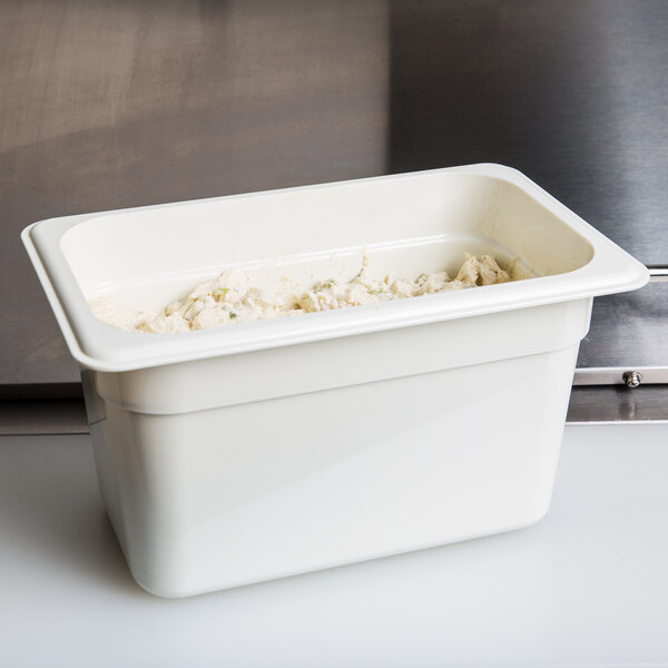 A white Cambro 1/4 size plastic food pan with food inside.