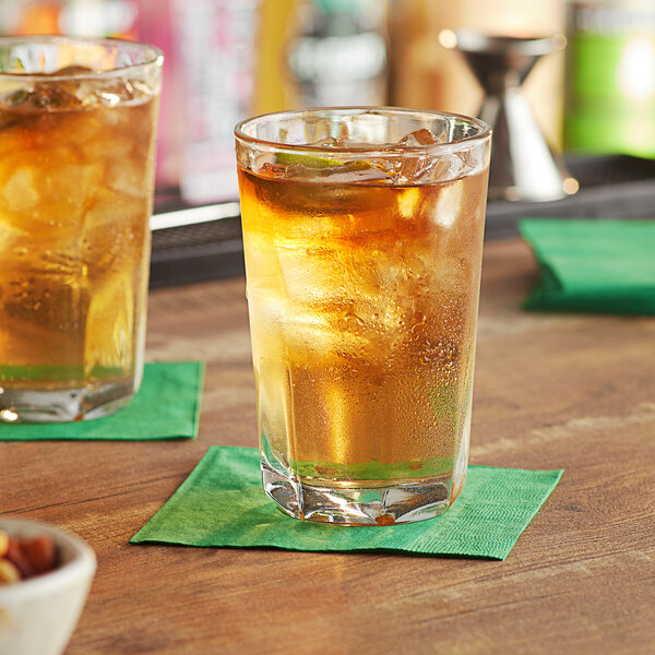 Two Anchor Hocking Clarisse beverage glasses of iced tea on a table with a green napkin.