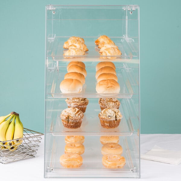 A clear Cal-Mil pastry display case filled with muffins and pastries.