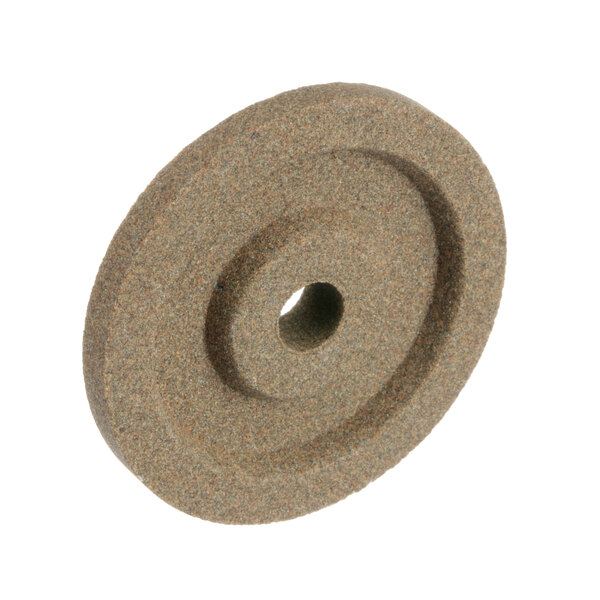 A Univex honing stone, a circular brown stone with a hole in the center.