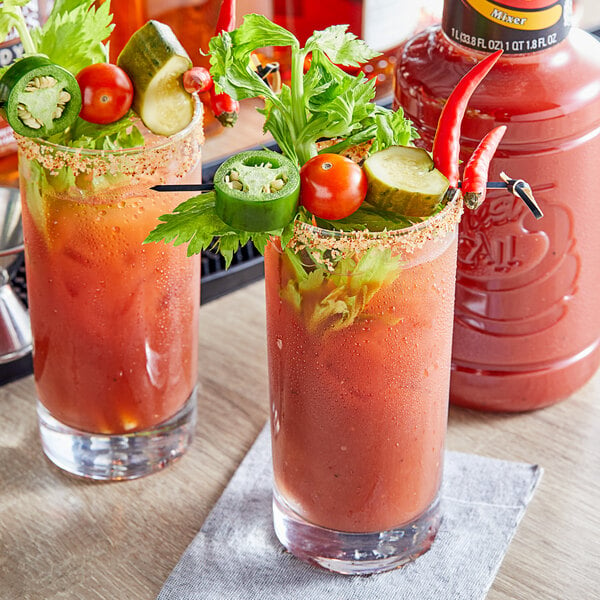 Two glasses of Finest Call Bloody Mary Mix garnished with vegetables.