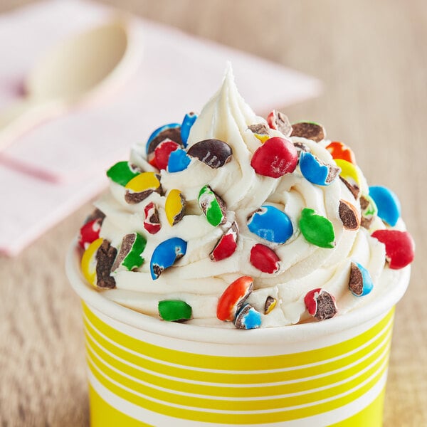 A cup of ice cream with M&M'S on top.