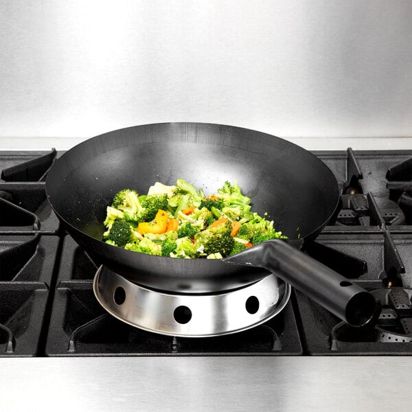 A Town 34700 14" Mandarin Wok with broccoli and carrots in it on a stove.