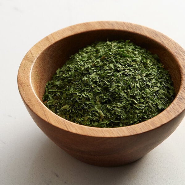 A bowl of Regal Parsley Flakes on a table.