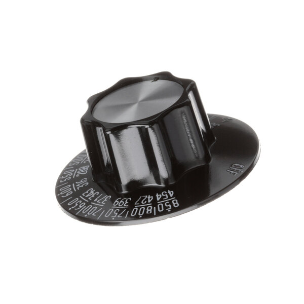 A close-up of a black and silver knob with white lettering.