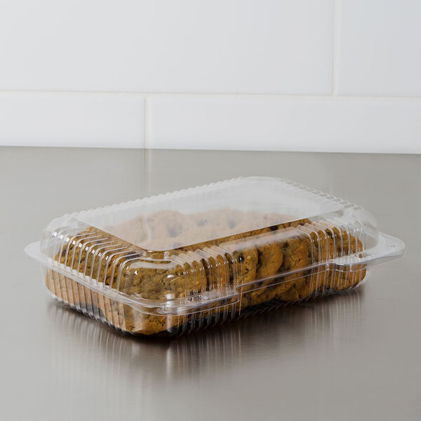 A Dart clear plastic container with cookies in it.