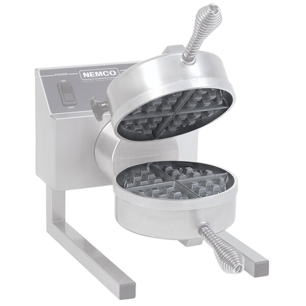 A Nemco waffle maker with two round waffles on it.