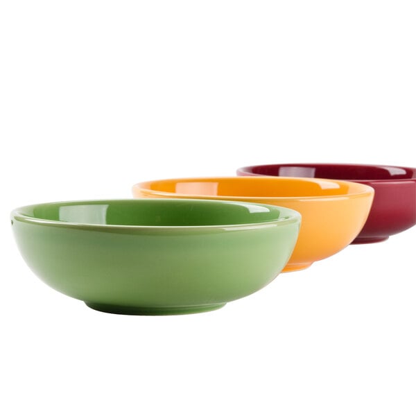 A close-up of a group of Tuxton menudo, pasta, and salad bowls in different colors.