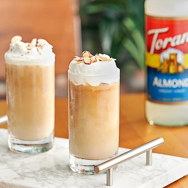 Two glasses of coffee with Torani Almond Flavoring Syrup and whipped cream.