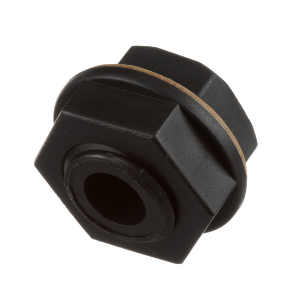 A close-up of a black plastic nut with a brown band.