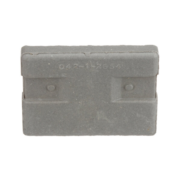 A grey rectangular object with numbers and letters and a circle in the middle, the US Range 2195700 bottom large block.