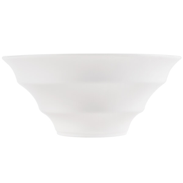 A close-up of a CAC bone white porcelain bowl with a curved design.