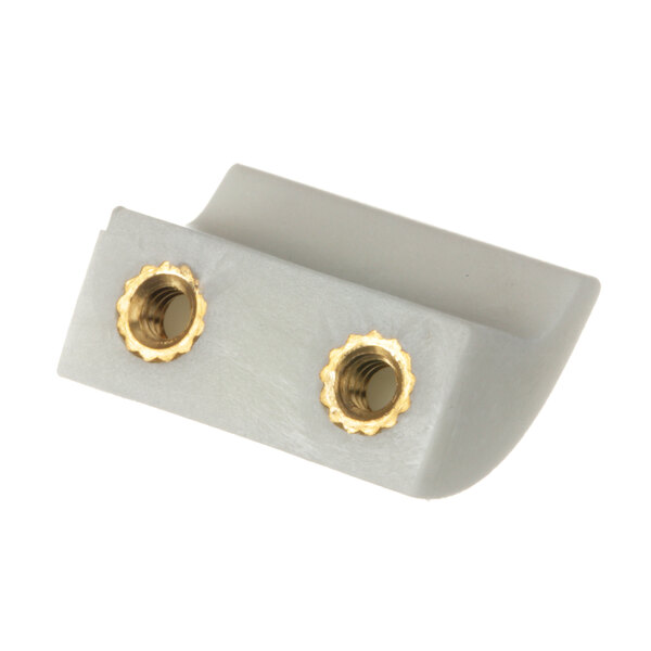 A close-up of a pair of brass knobs on a piece of white plastic.