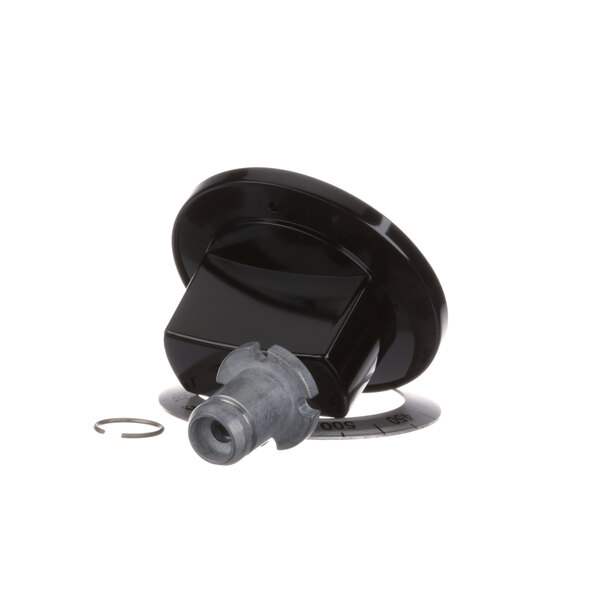 A close-up of a black plastic US Range knob with a metal ring.
