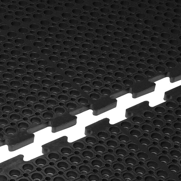 A close-up of a black Cactus Mat with holes in it.