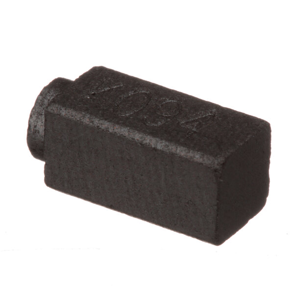 A black rectangular carbon brush with a hole in it.