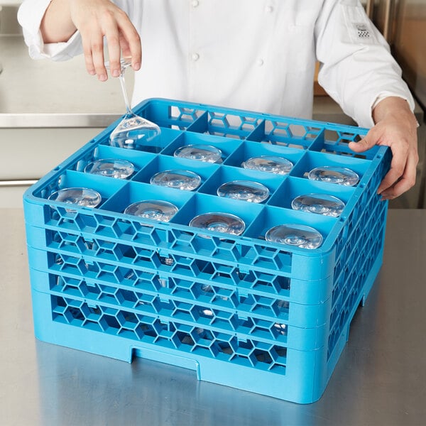 A person putting glasses in a Carlisle blue glass rack.