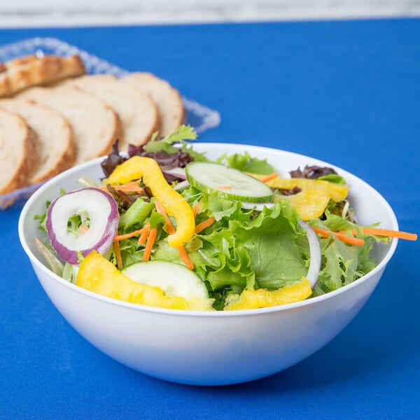A white plastic bowl filled with salad with slices of bread on the side.