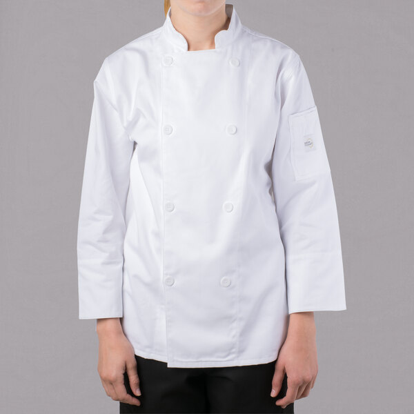 A woman wearing a white Mercer Culinary Genesis long sleeve chef jacket.