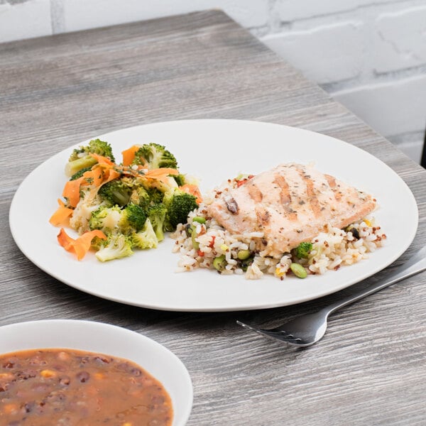 A 10 Strawberry Street white stoneware plate with rice, broccoli, and chicken on a table.