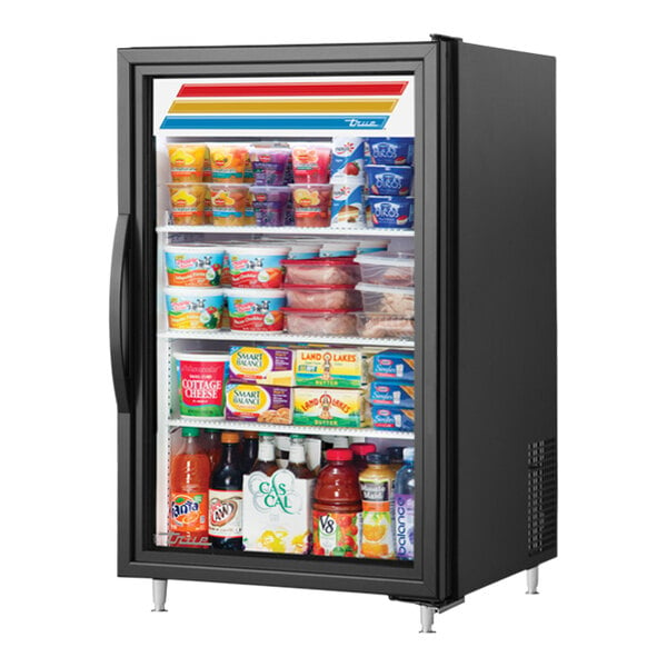 A True black countertop glass door refrigerator full of food on shelves.