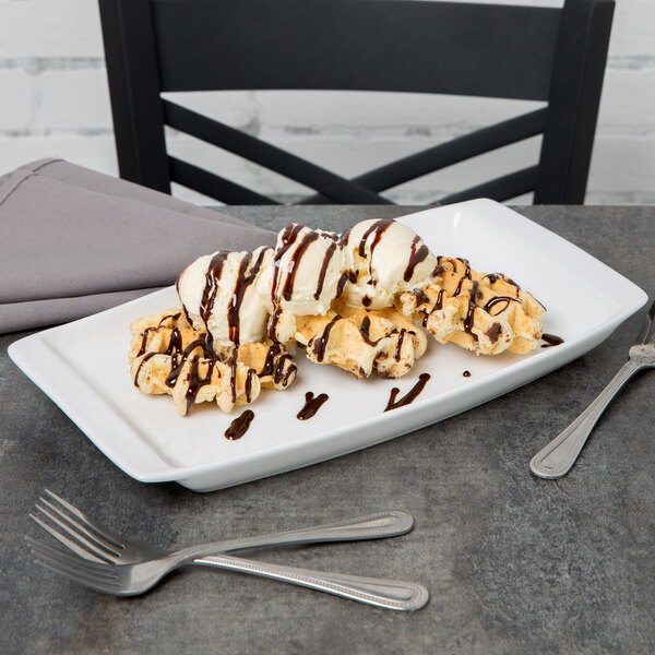 A Libbey Aluma White porcelain handled tray with waffles, ice cream, and chocolate syrup.