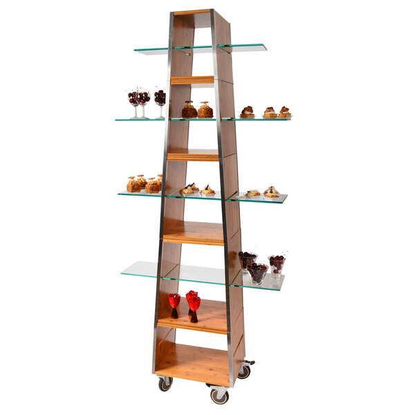 An Eastern Tabletop wood pyramid rolling buffet with interconnecting cubbies holding desserts on glass shelves.