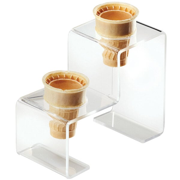 A clear plastic stand with two ice cream cones in it.