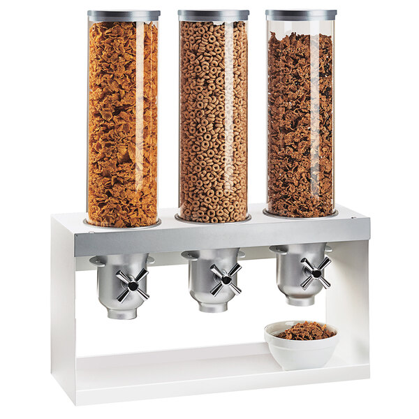 A Cal-Mil Luxe silver triple cereal dispenser with bowls on top.